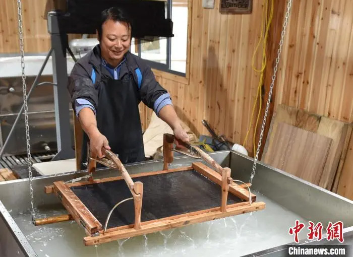 黃宏健在工廠(chǎng)造紙